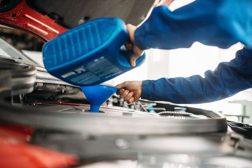 Technician change oil in the car engine. Vehicle motor maintenance, auto-service - Oil Change Maple Ridge